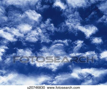Stock Image - Blue sky and Clouds, Low angle view, Full frame. Fotosearch