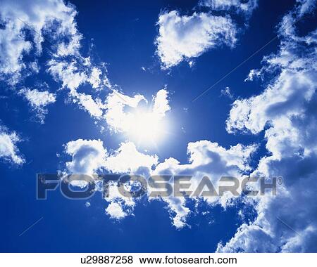 Stock Photo - Blue sky and Clouds with Sun, Low angle view. Fotosearch
