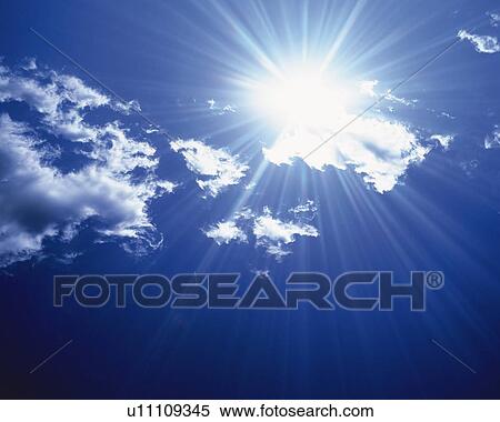 Stock Photography - Blue sky and Clouds with Sun, Low angle view, Lens Flare. Fotosearch