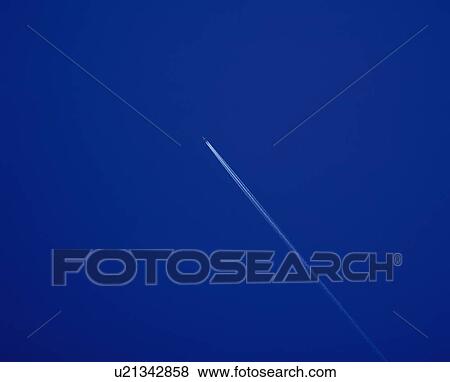 Stock Photo - Contrail in Blue sky, Low angle view, Copy Space, . Fotosearch