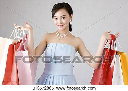 Young woman in formal dress holding shopping bags View Large Photo Image Stock Photography - Young woman in formal dress holding shopping bags. Fotosearch