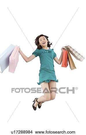 Young woman leaping with holding shopping bags View Large Photo Image Picture - Young woman leaping with holding shopping bags. Fotosearch