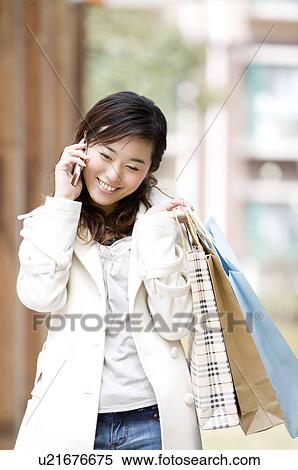 Young woman on the phone with shopping bags View Large Photo Image Stock Photography - Young woman on the phone with shopping bags. Fotosearch