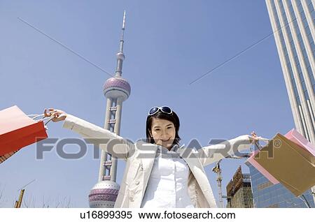 Young woman outstretching her arm with shopping bags View Large Photo Image Stock Photography - Young woman outstretching her arm with shopping bags. Fotosearch