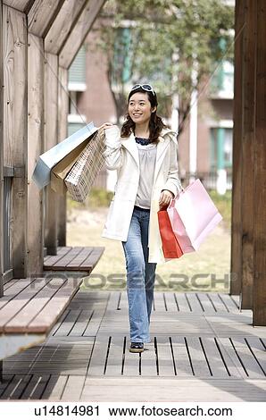Young woman raising shopping bags View Large Photo Image Stock Image - Young woman raising shopping bags. Fotosearch