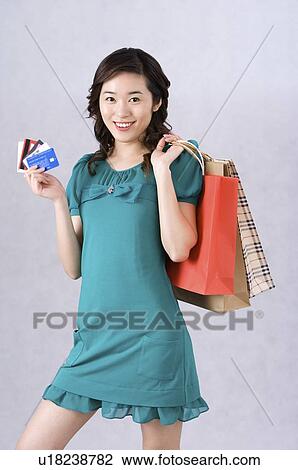 Young woman showing her bank cards with shopping bags over shoulder View Large Photo Image Stock Image - Young woman showing her bank cards with shopping bags over shoulder. Fotosearch