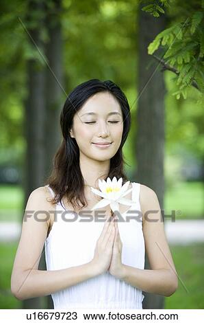 Young woman holding single flower outdoors View Large Photo Image Stock Image - Young woman holding single flower outdoors. Fotosearch
