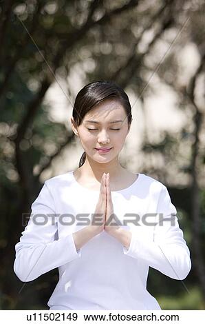 Stock Photo - Young woman in praying position. Fotosearch