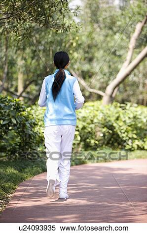 Young woman jogging in park View Large Photo Image Stock Photography - Young woman jogging in park. Fotosearch