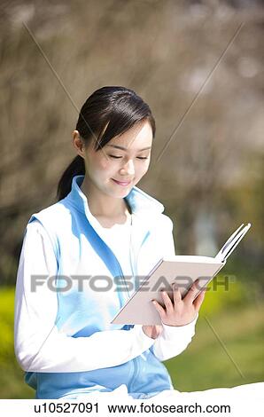 Young woman reading book outdoors View Large Photo Image Stock Image - Young woman reading book outdoors. Fotosearch