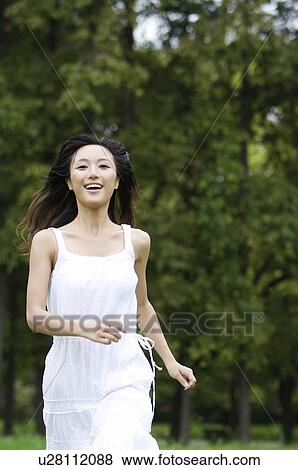 Stock Photo - Young woman running outdoors. Fotosearch