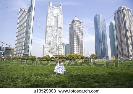 Young woman sitting in lotus position on lawn View Large Photo Image Stock Image - Young woman sitting in lotus position on lawn. Fotosearch