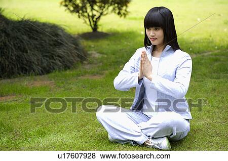 Young woman sitting on lawn in prayer position View Large Photo Image Stock Photo - Young woman sitting on lawn in prayer position. Fotosearch