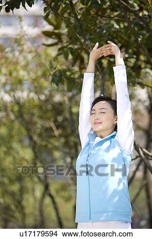 Young woman stretching outdoors View Large Photo Image Picture - Young woman stretching outdoors. Fotosearch