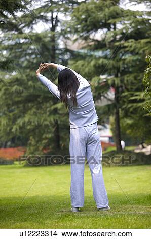 Young woman stretching outdoors, rear view View Large Photo Image Picture - Young woman stretching outdoors, rear view. Fotosearch