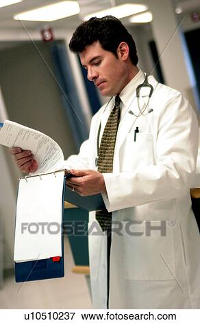 Doctor looking at patient chart Doctor looking at patient chart View Large Photo Image Stock Photo - Doctor looking at patient chart Doctor looking at patient chart . Fotosearch