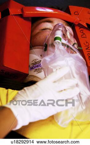 Picture - EMT working on patient on stretcher. Fotosearch