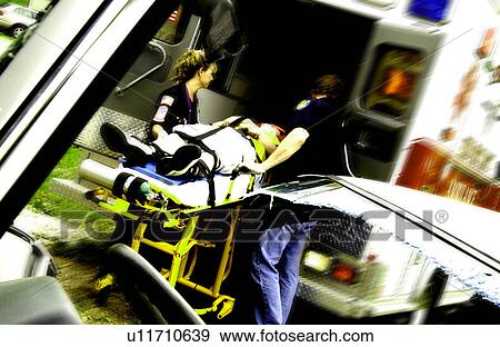 EMTs loading patient into ambulance View Large Photo Image Stock Photo - EMTs loading patient into ambulance. Fotosearch