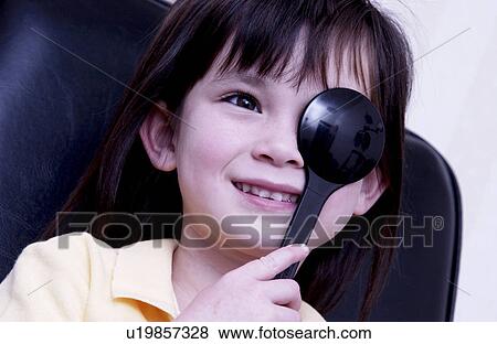 Stock Photo - Girl getting vision tested. Fotosearch