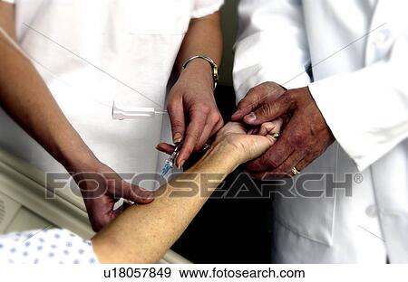 Nurse setting up an IV View Large Photo Image Stock Photo - Nurse setting up an IV. Fotosearch