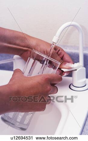 Woman getting a glass of water View Large Photo Image Stock Image - Woman getting a glass of water. Fotosearch