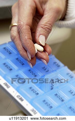 Woman putting pills into pill divider View Large Photo Image Stock Image - Woman putting pills into pill divider. Fotosearch