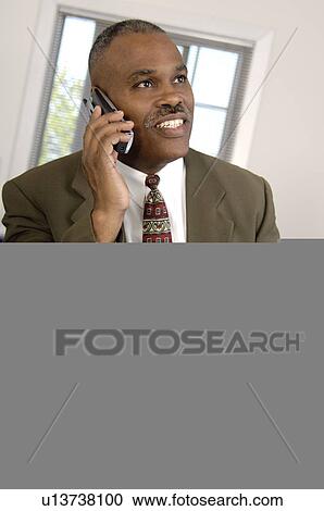 Stock Image - African American businessman on cordless phone. Fotosearch