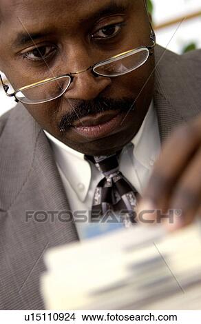 Businessman looking on rolodex View Large Photo Image Picture - Businessman looking on rolodex. Fotosearch