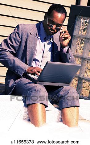 Businessman on laptop by hot tub View Large Photo Image Stock Photo - Businessman on laptop by hot tub. Fotosearch