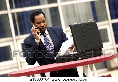 Businessman talking on phone ouside View Large Photo Image Picture - Businessman talking on phone ouside. Fotosearch