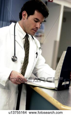 Doctor looking at patient chart View Large Photo Image Picture - Doctor looking at patient chart . Fotosearch