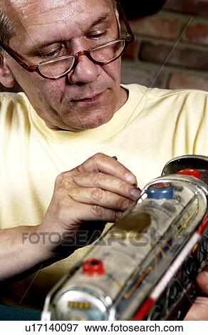 Stock Photo - Man repairing a model train. Fotosearch