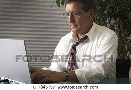 Man working on a laptop View Large Photo Image Stock Photo - Man working on a laptop. Fotosearch
