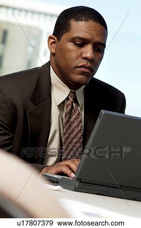 Stock Photo - Man working on laptop. Fotosearch
