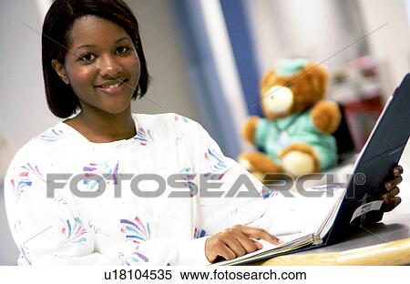 African American nurse looking at patient chart View Large Photo Image Stock Photography - African American nurse looking at patient chart. Fotosearch