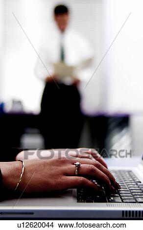 Businesswoman typing on computer in office environment View Large Photo Image Picture - Businesswoman typing on computer in office environment. Fotosearch
