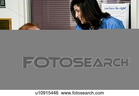 Stock Photograph - Nurse giving senior woman pills. Fotosearch