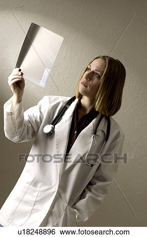Stock Photograph - Physician looking at xrays. Fotosearch