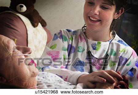 Senior woman holding hands with nurse View Large Photo Image Stock Photo - Senior woman holding hands with nurse. Fotosearch
