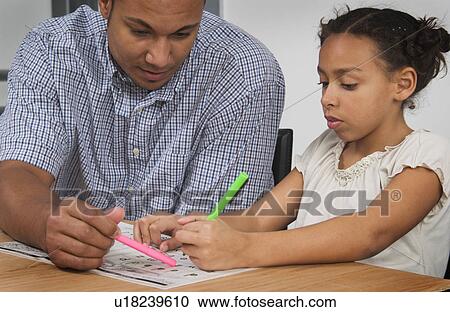 Stock Image - African American father helping daughter with homework. Fotosearch