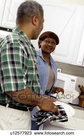 Stock Image - African American senior couple washing dishes. Fotosearch