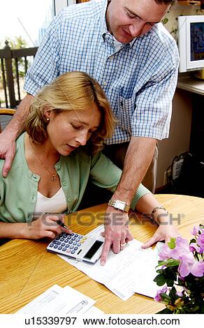 Couple looking over bills View Large Photo Image Stock Photo - Couple looking over bills. Fotosearch