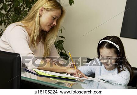 Mother helping daughter with homework View Large Photo Image Picture - Mother helping daughter with homework. Fotosearch