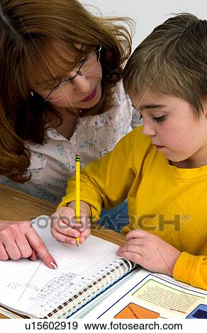 Stock Photo - Mother or teacher helping boy with homework. Fotosearch