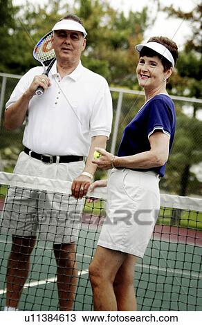 Stock Image - Senior couple playing tennis. Fotosearch