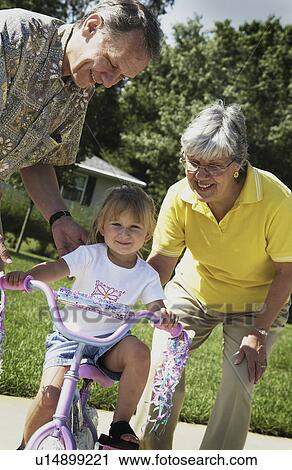 Stock Image - Young girl learning to ride bicycle. Fotosearch