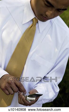 Stock Photo - Businessman dialing cell phone. Fotosearch