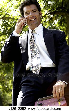 Businessman on cell phone on a teeter totter View Large Photo Image Stock Image - Businessman on cell phone on a teeter totter. Fotosearch