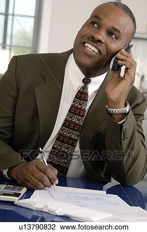 Stock Image - African American businessman on cordless phone. Fotosearch