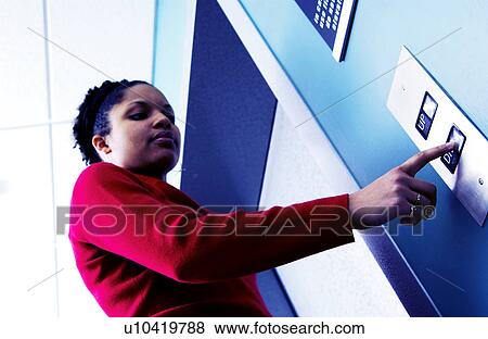 Stock Photo - African American woman pushing elevator button. Fotosearch